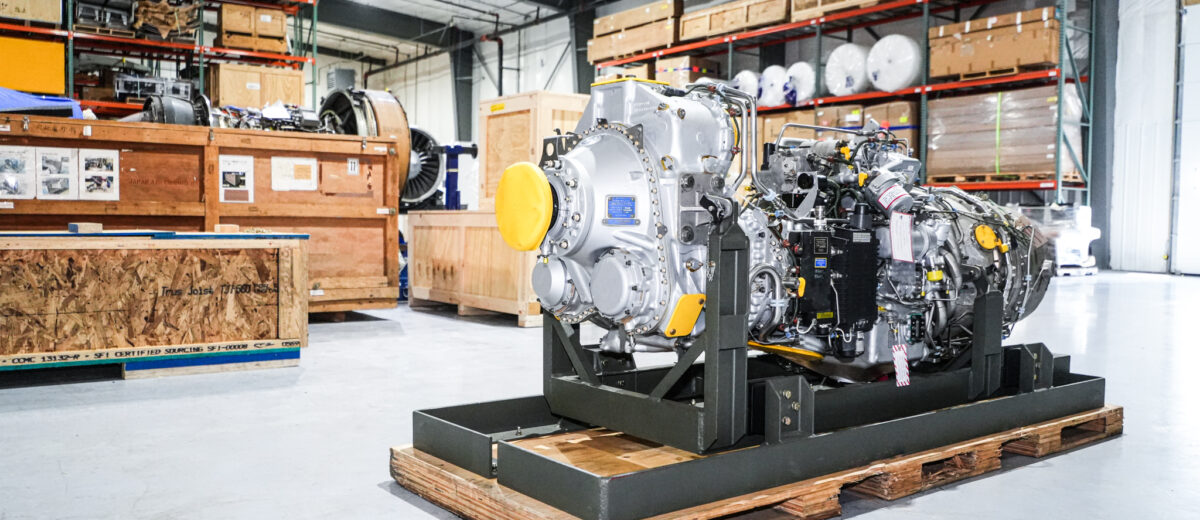 A large airplane engine standing on a wooden pallet in a warehouse