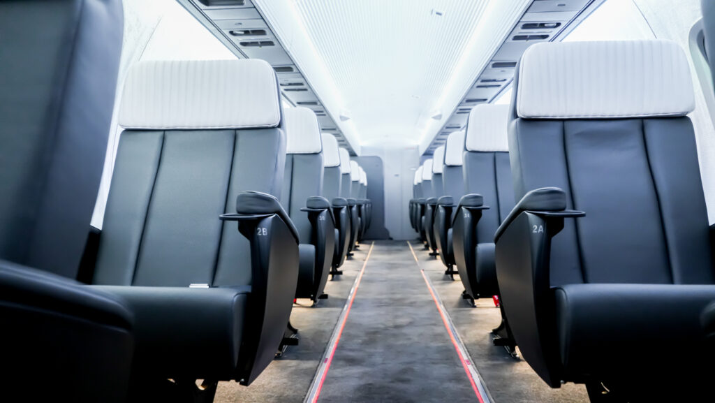 A photo of the inside of an airplane cabin, with focus on the chairs