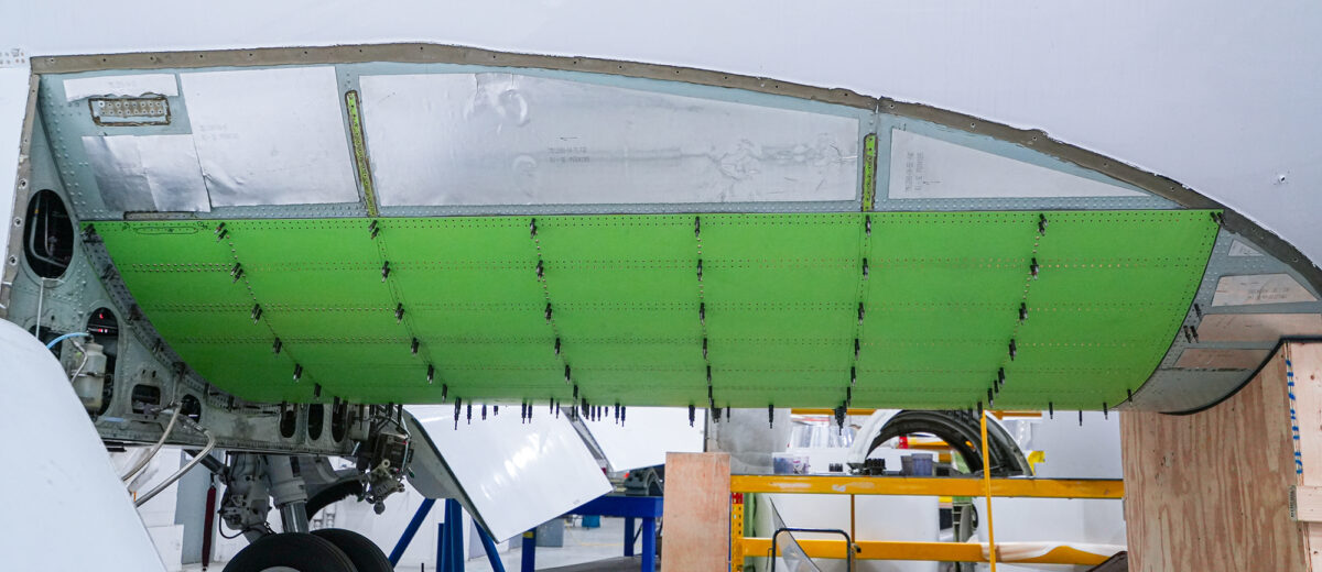 A photo of a bright green section of the underside of an airplane